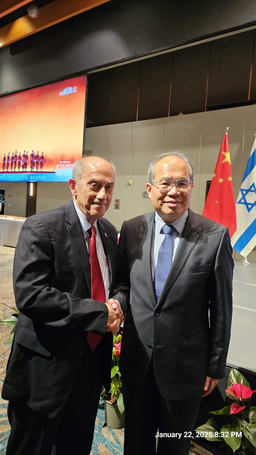 Dr. Topaz with the Ambassador of China to Israel, against the flags of both countries