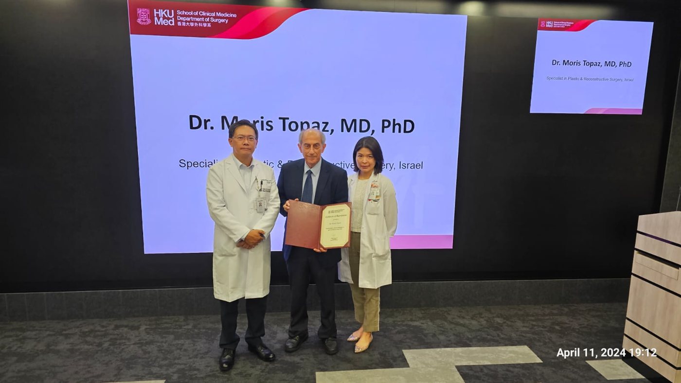 Dr. Topaz receiving a Certificate of Appreciation on stage at the University of Hong Kong